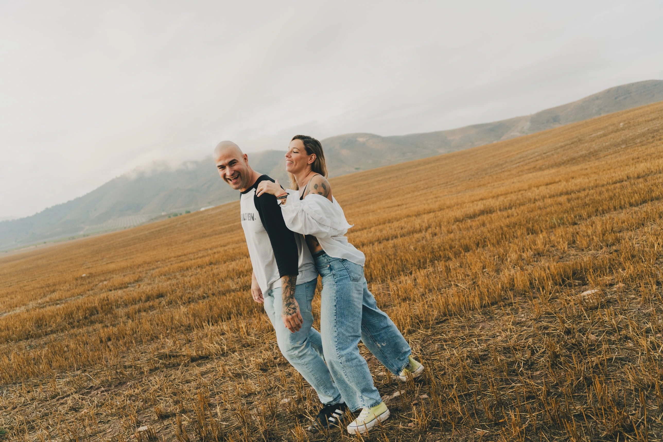 Los dos caminando abrazados por el campo segado