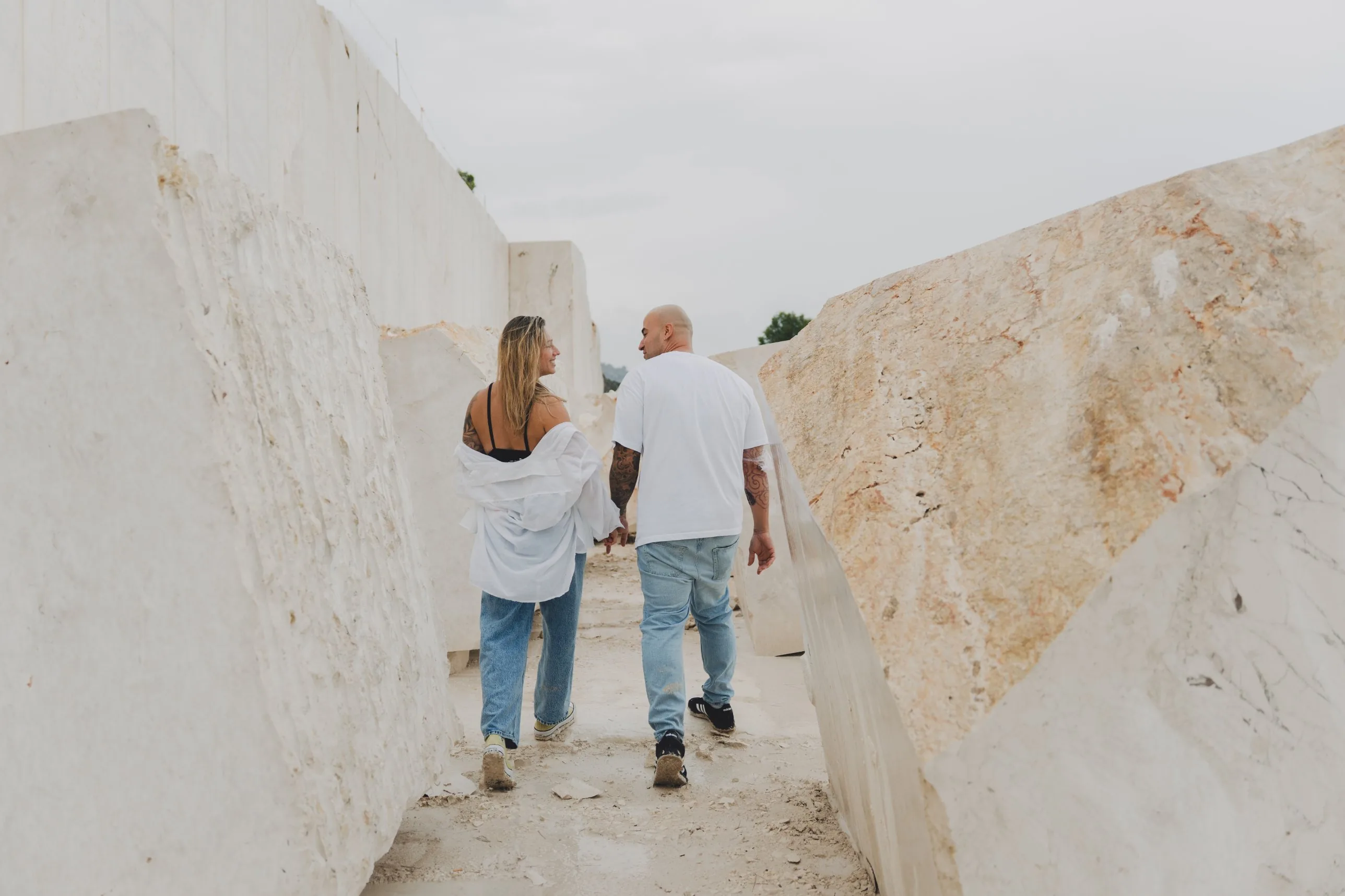 De espaldas, caminando entre los bloques blancos de la cantera