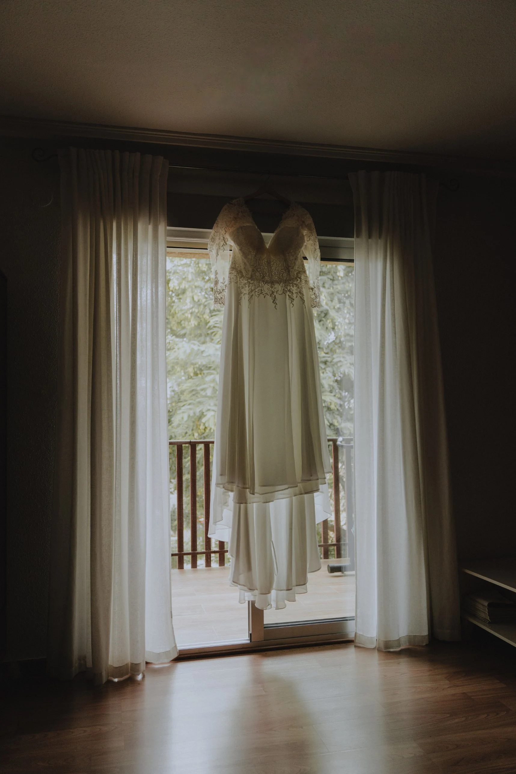 El vestido colgado a contraluz en la ventana